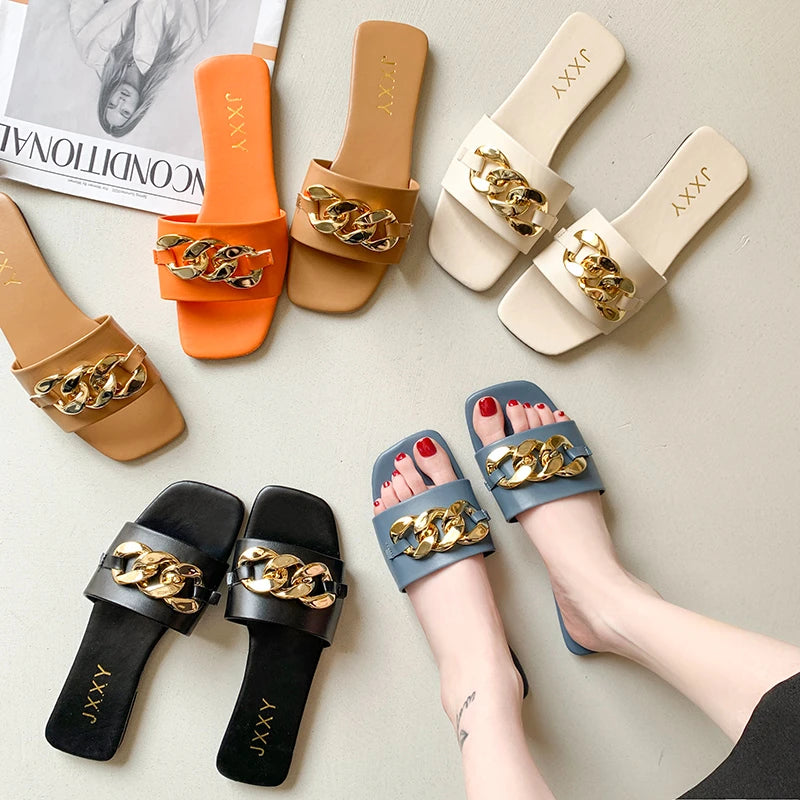 Nuevas pantuflas de moda para mujer 2025: sandalias planas tipo pala con punta cuadrada, detalle de cadena y adorno metálico; calzado casual y playero.