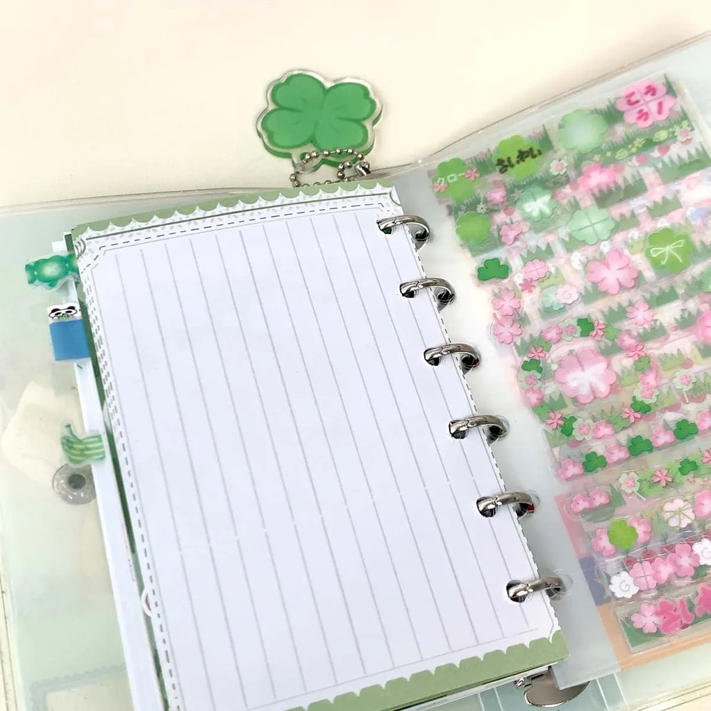 Carpeta WAKAWAKA tamaño A7 con diseño de trébol de cuatro hojas y chica; cuaderno de hojas intercambiables con cubierta de PVC brillante, incluye bolsillo para almacenamiento de pegatinas; portátil.