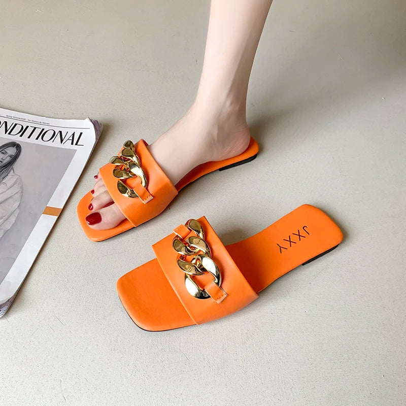 Nuevas pantuflas de moda para mujer 2025: sandalias planas tipo pala con punta cuadrada, detalle de cadena y adorno metálico; calzado casual y playero.