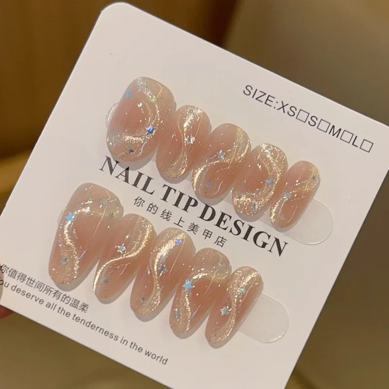Set de 10 uñas postizas hechas a mano con diseño de lazo, efecto ojo de gato y estrella de cinco puntas; forma ovalada mediana y estilo de aplicación a presión (press-on). Ideal como regalo para chicas.