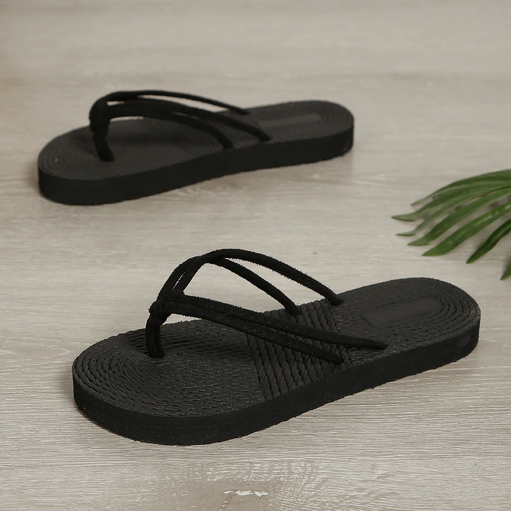 Tendencia de moda femenina: sandalias planas tipo chancla, antideslizantes y de color negro liso.