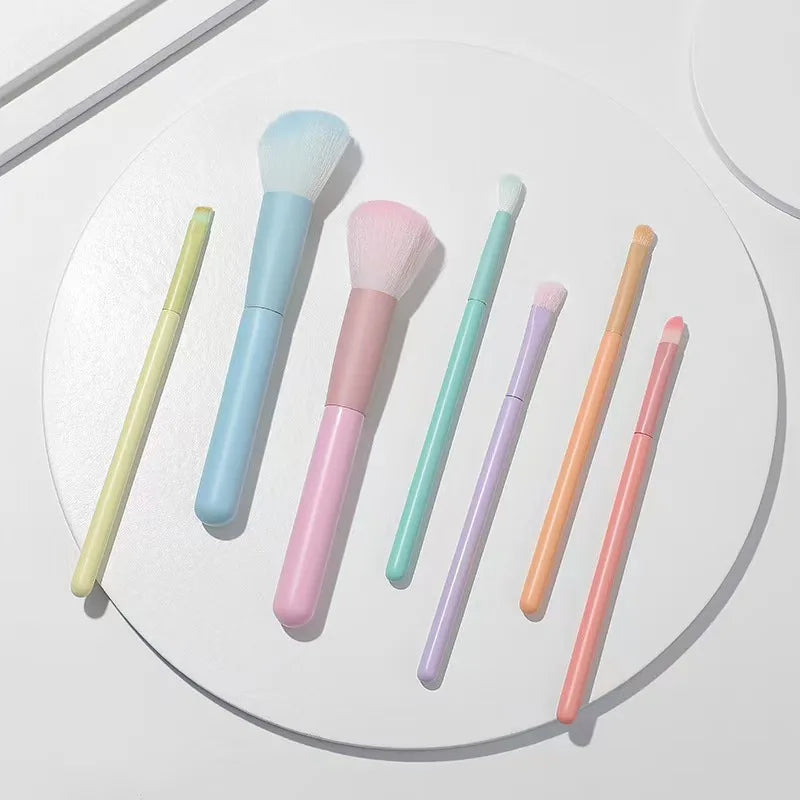 Un juego completo de herramientas de maquillaje que incluye 7 brochas de colores, polvos sueltos, productos para contorno, sombras de ojos, brochas para cejas, etc.