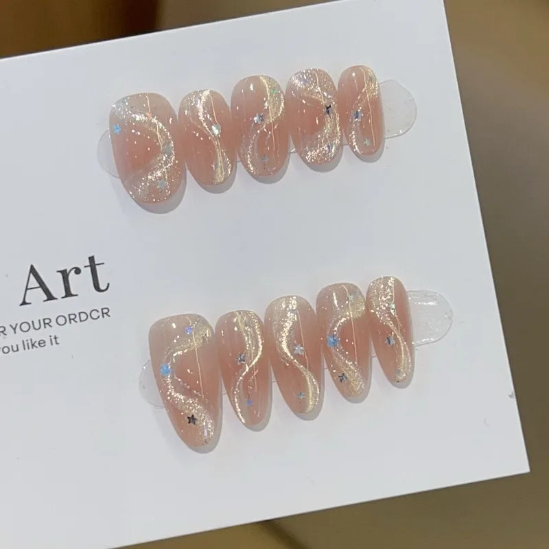 Set de 10 uñas postizas hechas a mano con diseño de lazo, efecto ojo de gato y estrella de cinco puntas; forma ovalada mediana y estilo de aplicación a presión (press-on). Ideal como regalo para chicas.