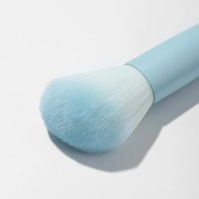 Un juego completo de herramientas de maquillaje que incluye 7 brochas de colores, polvos sueltos, productos para contorno, sombras de ojos, brochas para cejas, etc.