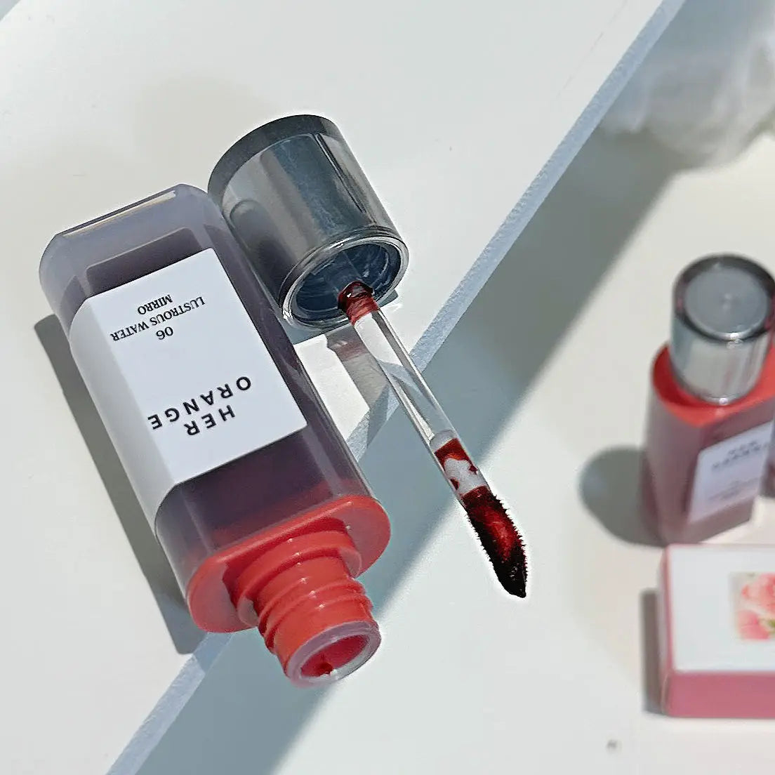 Tinta labial hidratante Herorange con acabado gloss y textura acuosa; efecto labios voluminosos y brillantes (tipo cristal). Fórmula de larga duración que no reseca