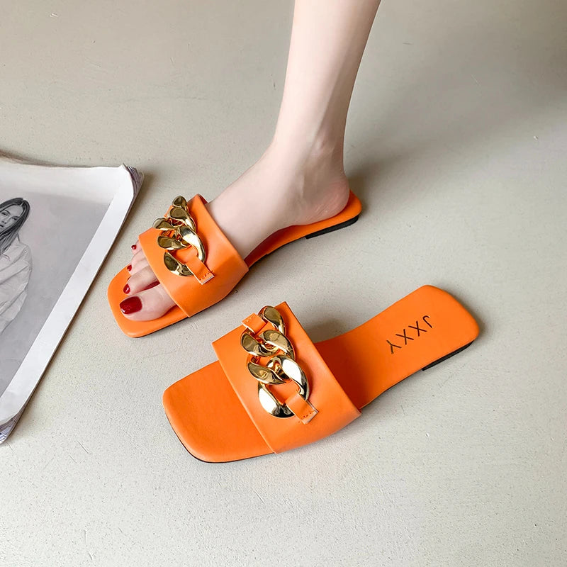 Nuevas pantuflas de moda para mujer 2025: sandalias planas tipo pala con punta cuadrada, detalle de cadena y adorno metálico; calzado casual y playero.
