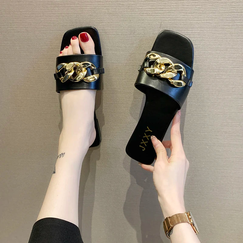 Nuevas pantuflas de moda para mujer 2025: sandalias planas tipo pala con punta cuadrada, detalle de cadena y adorno metálico; calzado casual y playero.